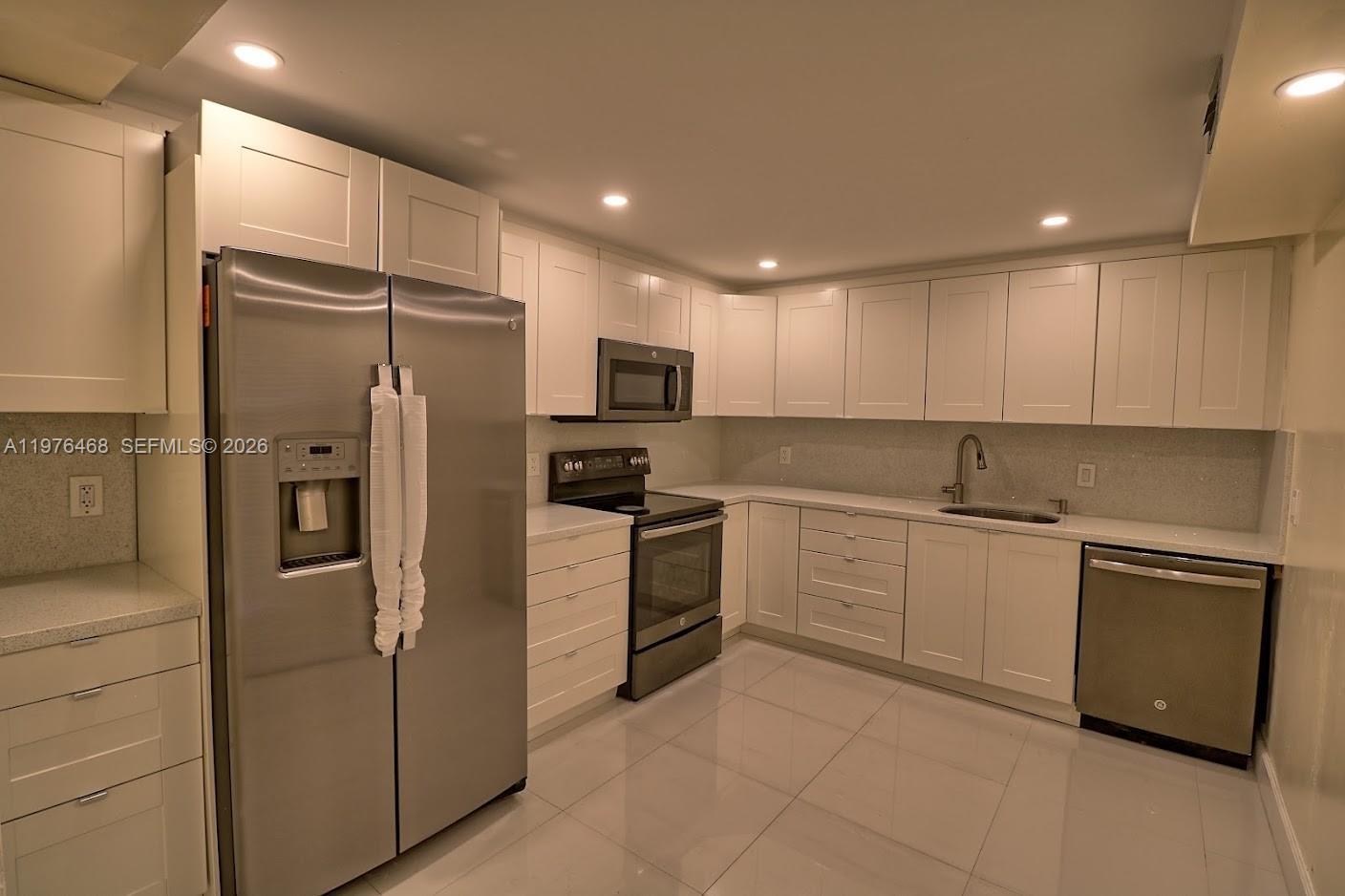 16500 Golf Club Road, Unit 205 Weston, FL 33326 - Photo 8 of 18 a kitchen with cabinets stainless steel appliances and a counter top space