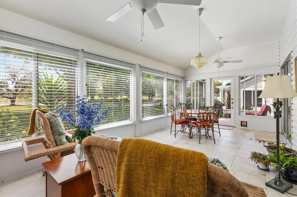 711 Agua Way Lady Lake, FL 32159 - Photo 12 of 16 a dining room with furniture a floor to ceiling window and a potted plant