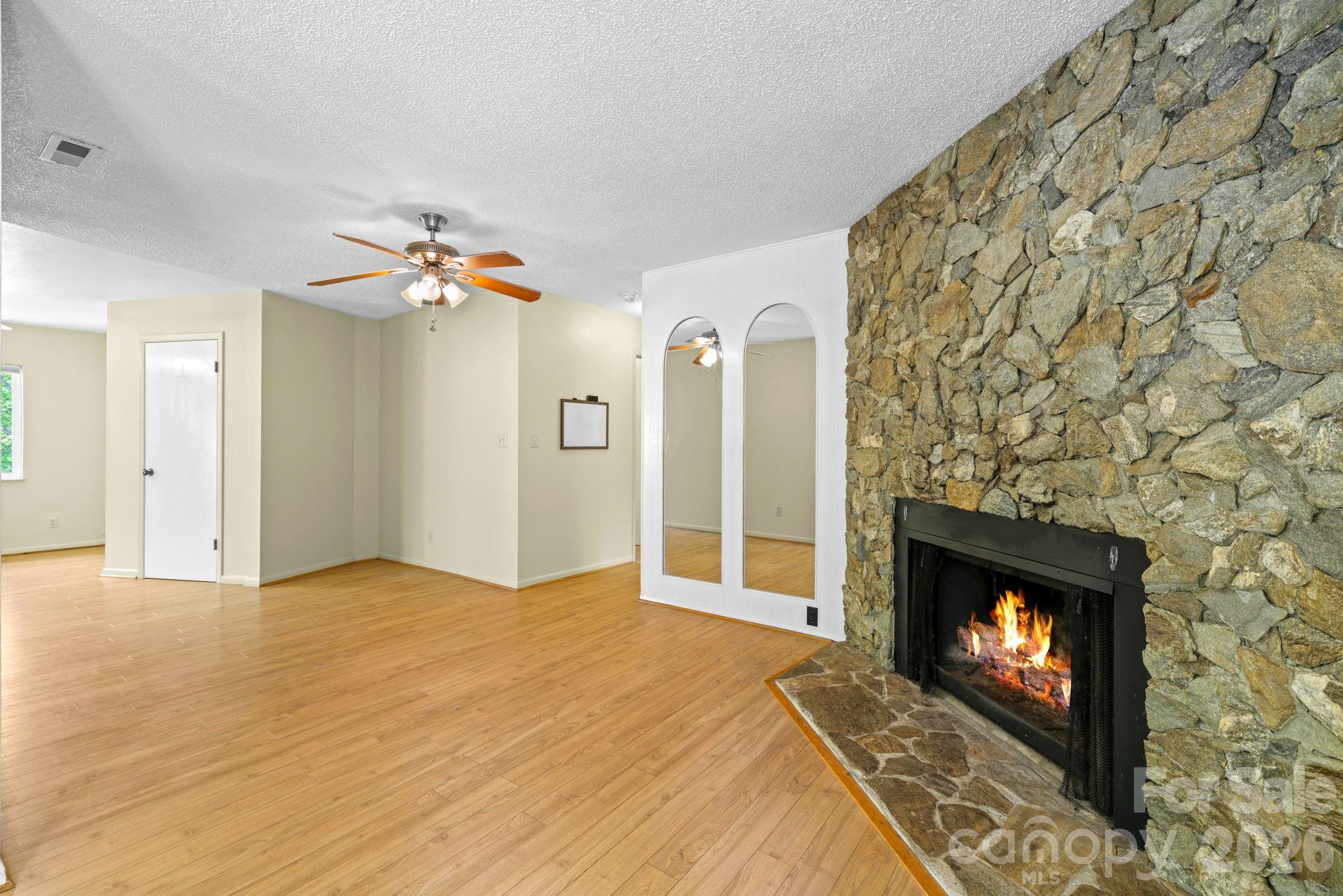 19 Quail Ridge Trail Franklin, NC 28734 - Photo 6 of 37 a view of an empty room with a fireplace and wooden floor