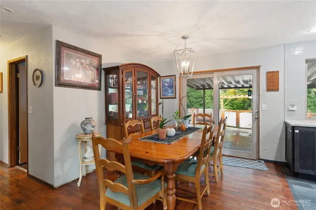 a view of a dining room with furniture a chandelier and wooden floor