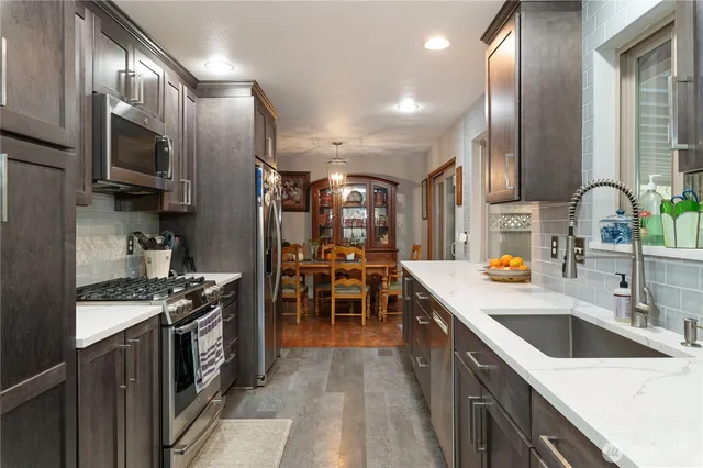 a kitchen with stainless steel appliances a sink stove and cabinets