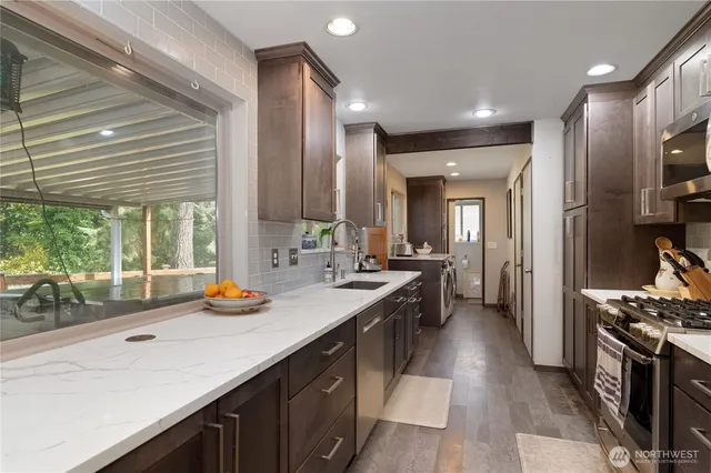 a kitchen with stainless steel appliances a sink stove and cabinets