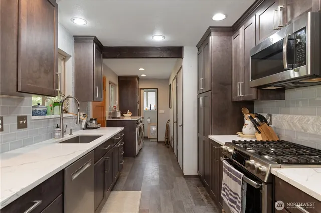 a kitchen with stainless steel appliances a sink stove and refrigerator