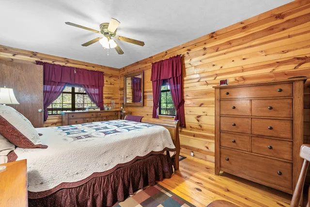 a bedroom with a bed a dresser and a window