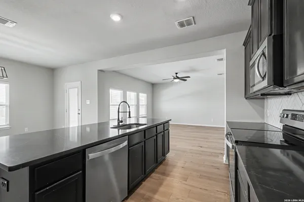 a kitchen with stainless steel appliances a sink stove and cabinets
