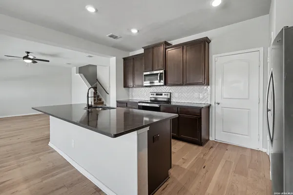 a kitchen with kitchen island granite countertop a sink stove and refrigerator