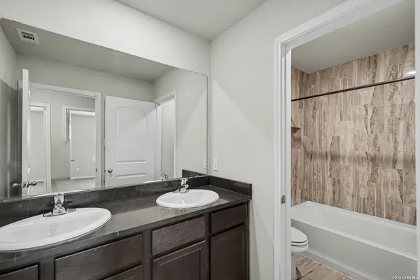 a bathroom with a granite countertop sink and a mirror
