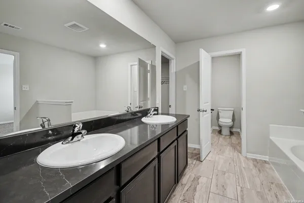 a bathroom with a sink double vanity granite and a mirror