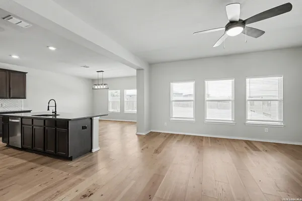 a view of a kitchen with wooden floor and stainless steel appliances