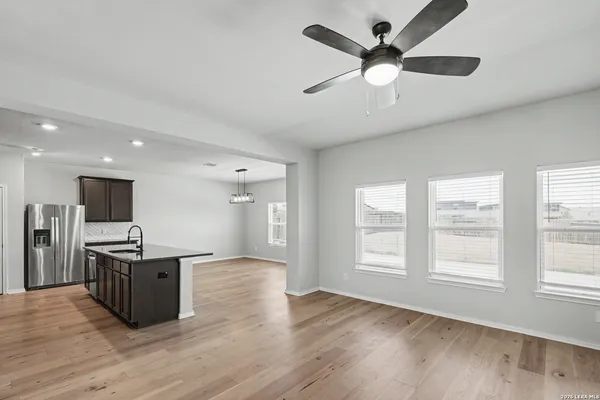 a living room with stainless steel appliances kitchen island hardwood floor and a window