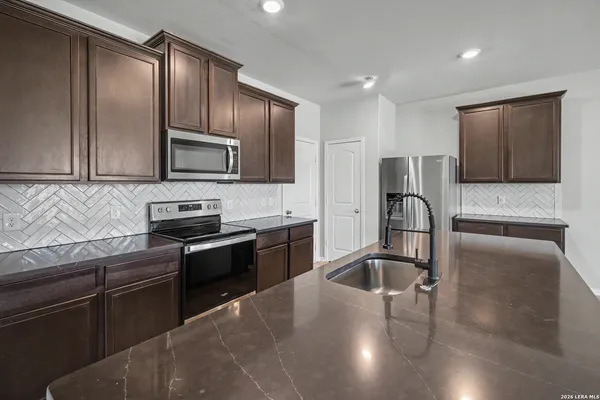 a kitchen with granite countertop stainless steel appliances and wooden cabinets