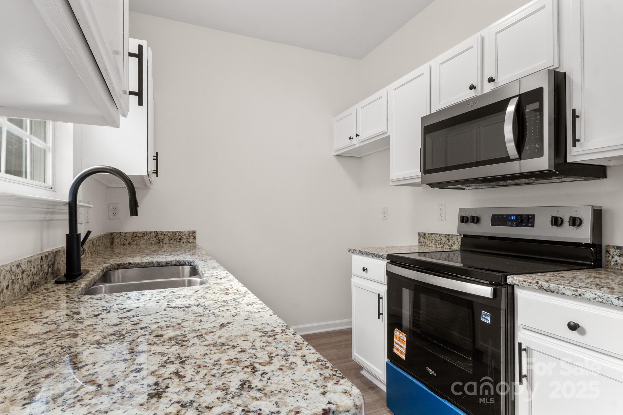 5529 Seths Drive Charlotte, NC 28269 - Photo 12 of 32 a kitchen with stainless steel appliances a stove a microwave and sink