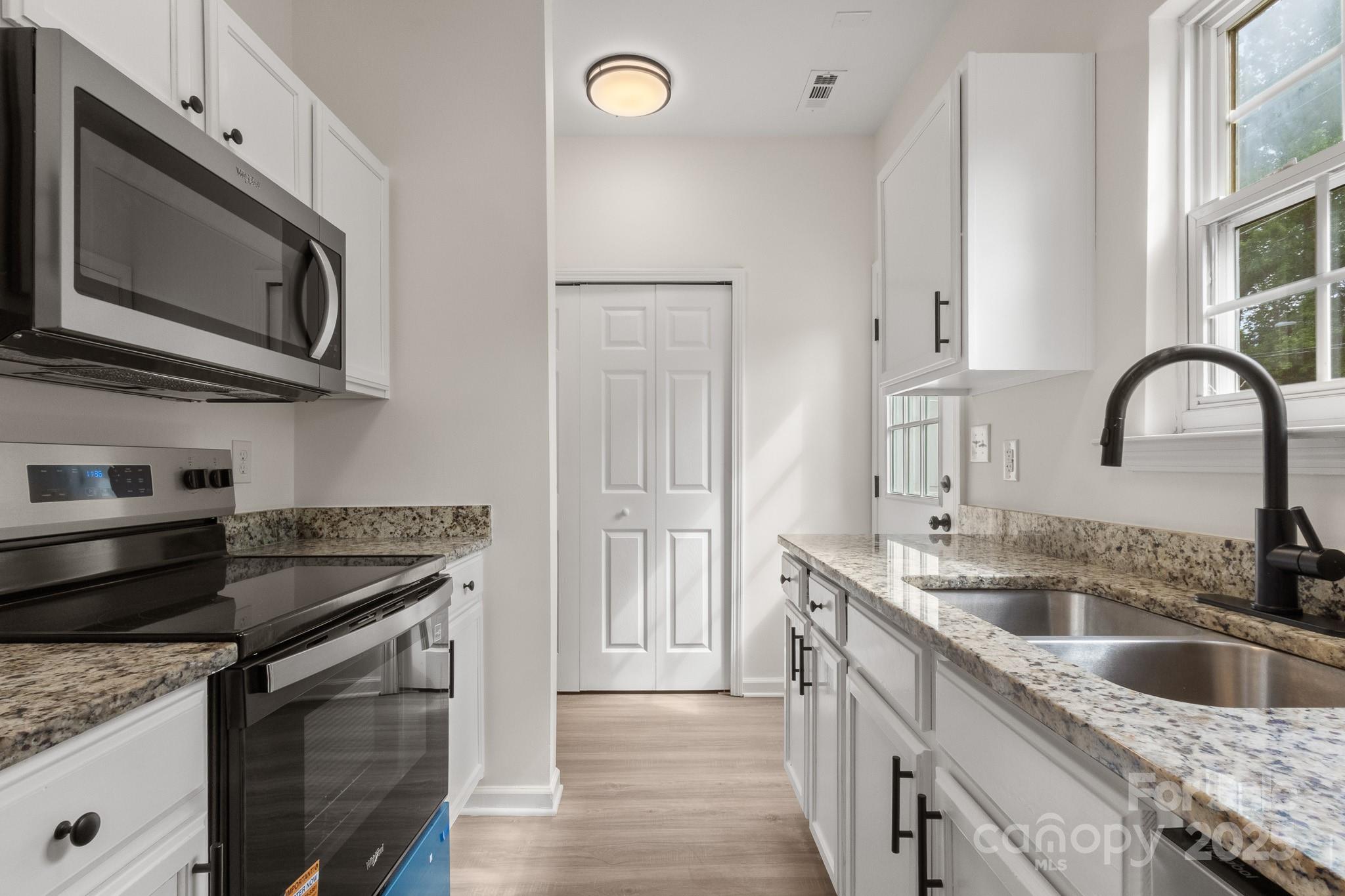 5529 Seths Drive Charlotte, NC 28269 - Photo 15 of 32 a kitchen with stainless steel appliances granite countertop a sink stove and microwave