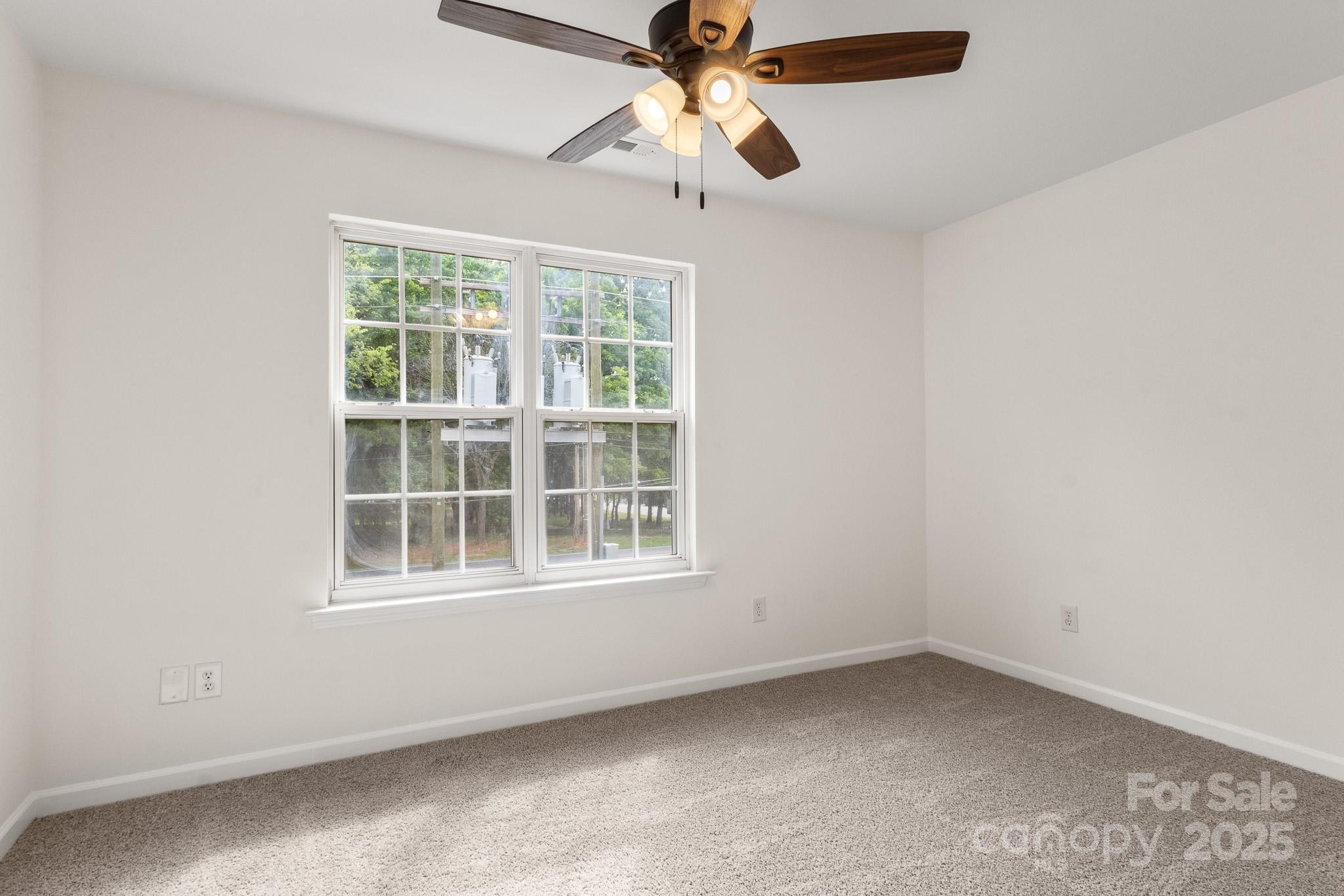 5529 Seths Drive Charlotte, NC 28269 - Photo 23 of 32 an empty room with a window and a fan