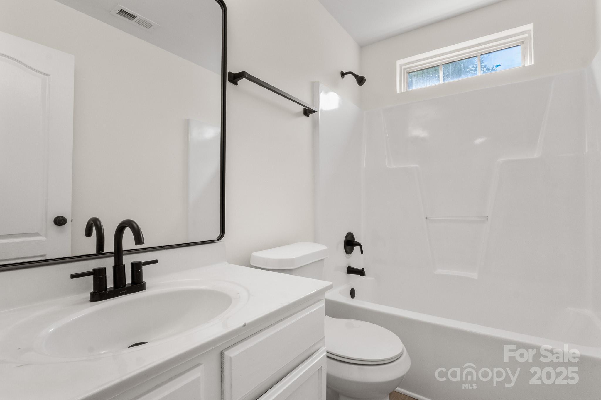 5529 Seths Drive Charlotte, NC 28269 - Photo 24 of 32 a bathroom with a sink a toilet and a mirror