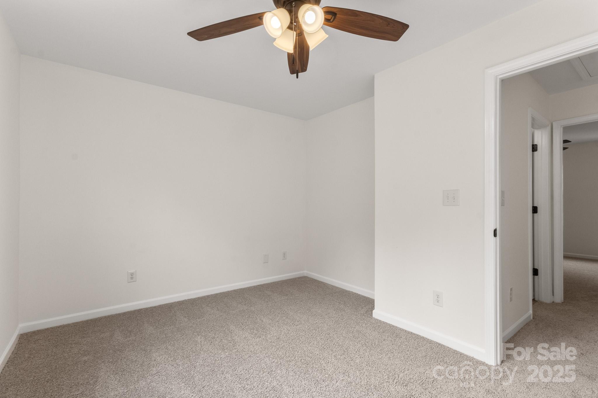 5529 Seths Drive Charlotte, NC 28269 - Photo 27 of 32 an empty room with a chandelier fan