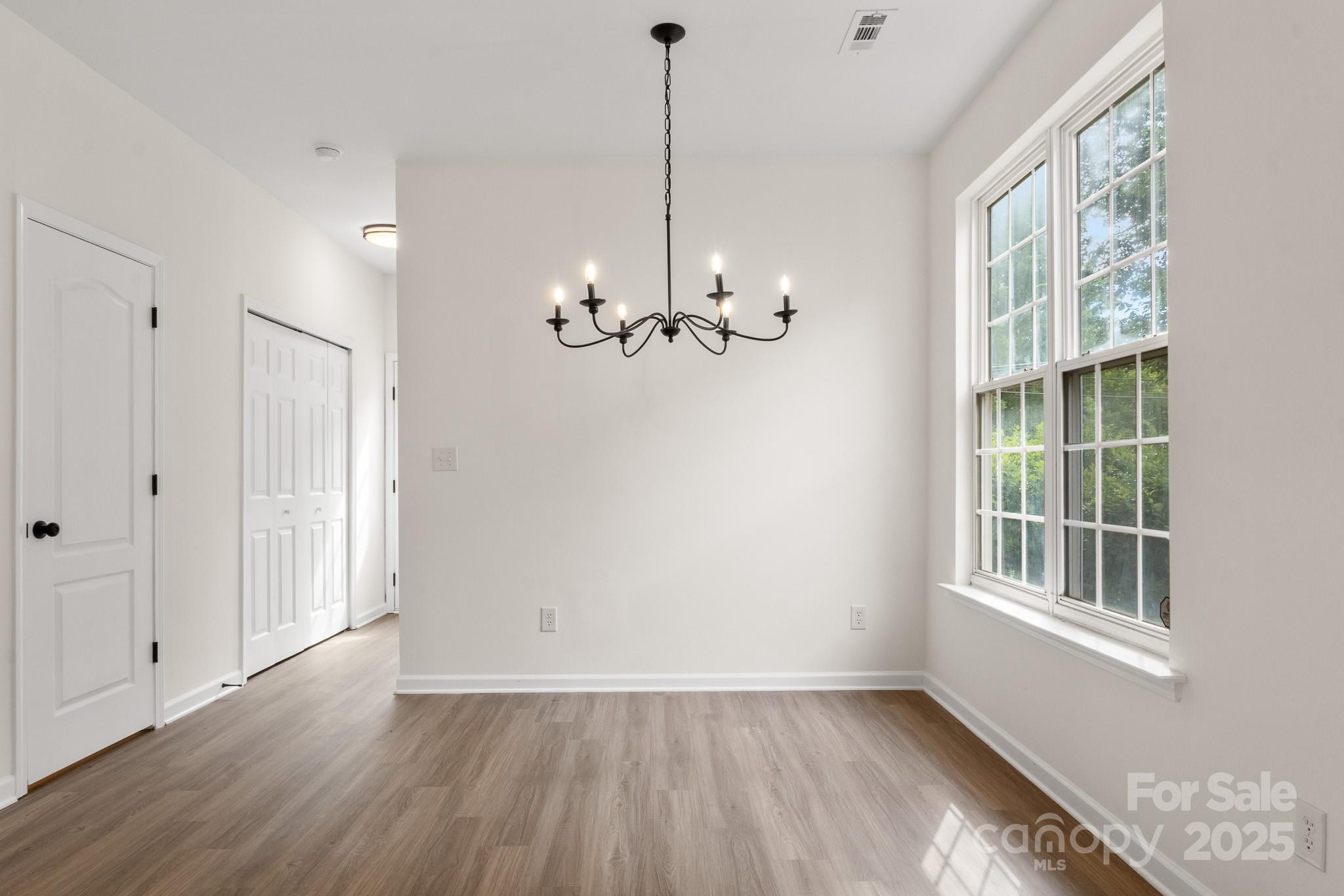 5529 Seths Drive Charlotte, NC 28269 - Photo 5 of 32 a view of empty room with wooden floor and fan