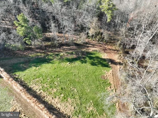 a view of a dry yard with wooden fence