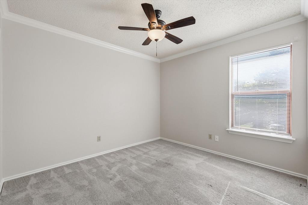318 Lodge Road Coppell, TX 75019 - Photo 27 of 35 A bright, versatile bedroom with generous wall space, soft carpeting and a ceiling fan for year-round comfort.