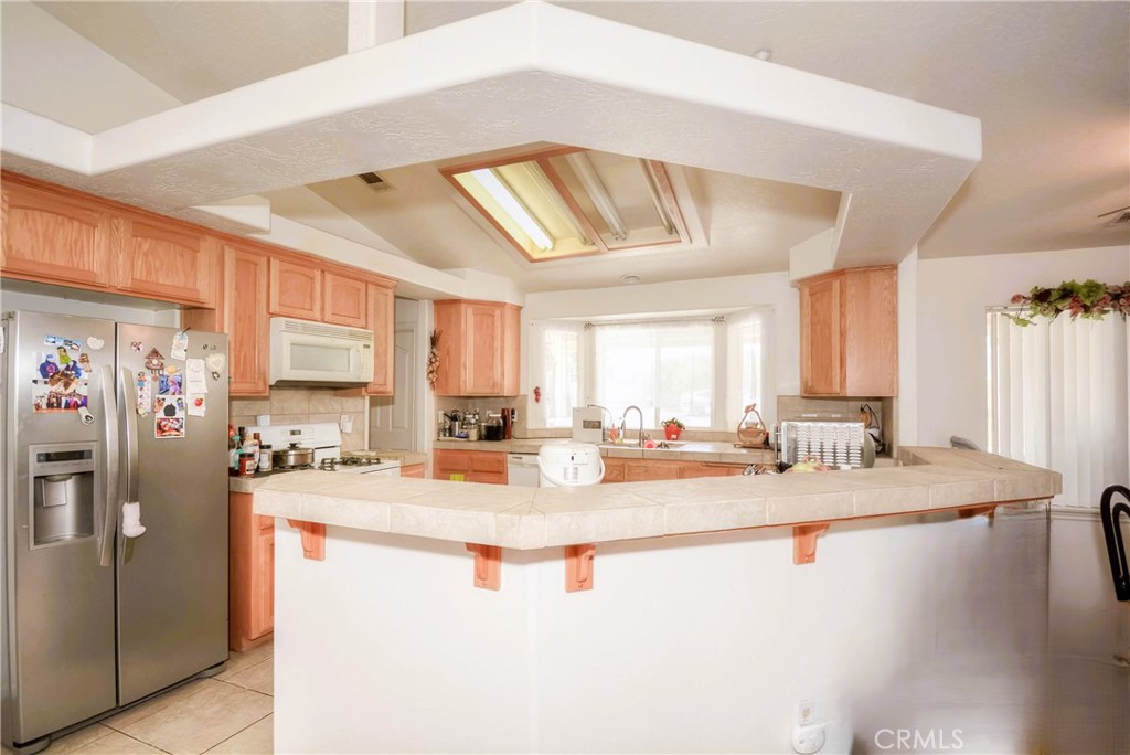 9331 Manada Road Phelan, CA 92371 - Photo 11 of 38 a kitchen with sink refrigerator and cabinets
