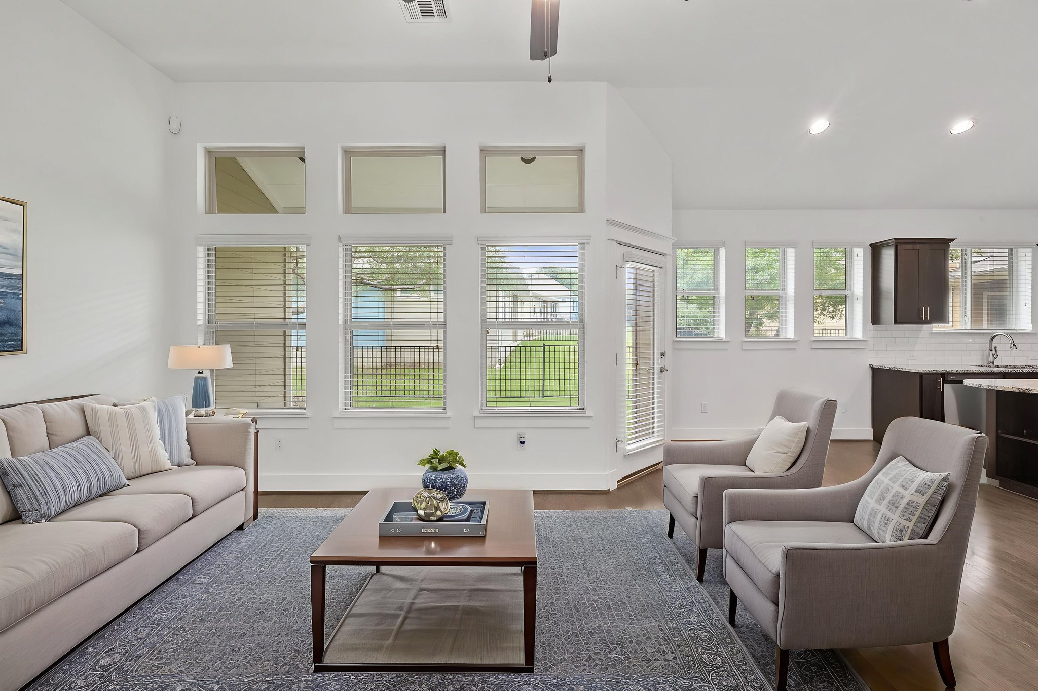 1765 Rowdy Loop, Unit 47 Leander, TX 78641 - Photo 12 of 39 Open-concept living area featuring high ceilings, wood-finish flooring, and multiple windows with blinds