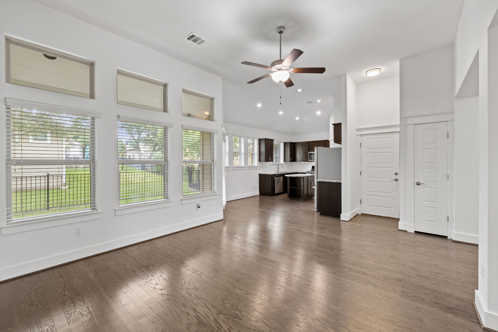 1765 Rowdy Loop, Unit 47 Leander, TX 78641 - Photo 14 of 39 Open-concept living area featuring rich wood-finish flooring, a contemporary ceiling fan, and recessed lighting