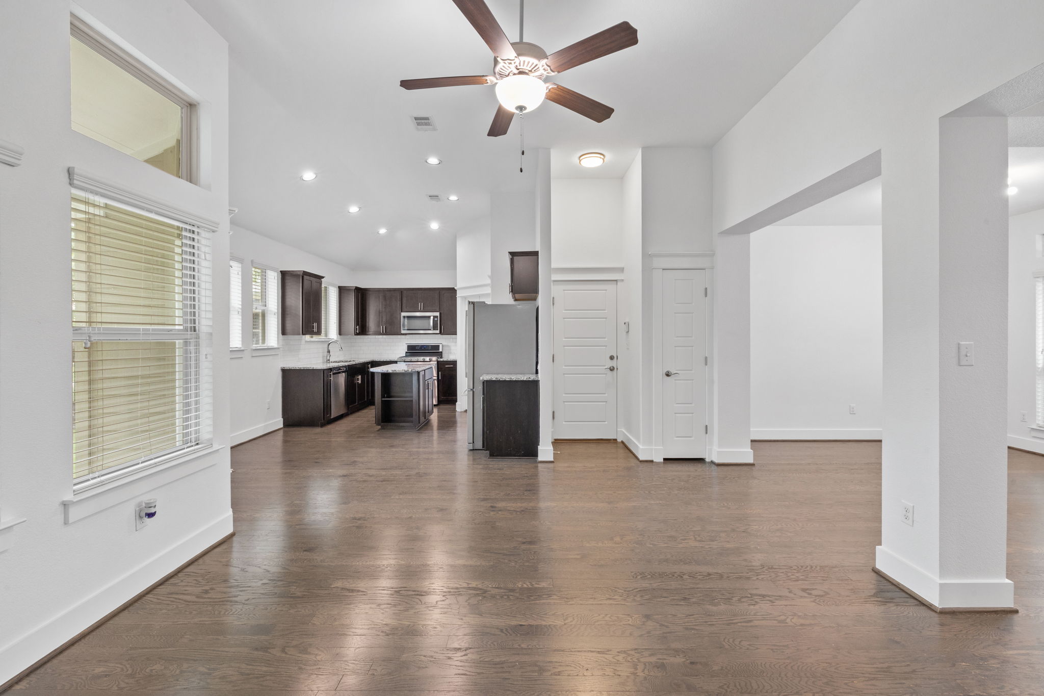 1765 Rowdy Loop, Unit 47 Leander, TX 78641 - Photo 20 of 39 Open-concept living area featuring wood-finish flooring, high ceilings, recessed lighting, and a ceiling fan