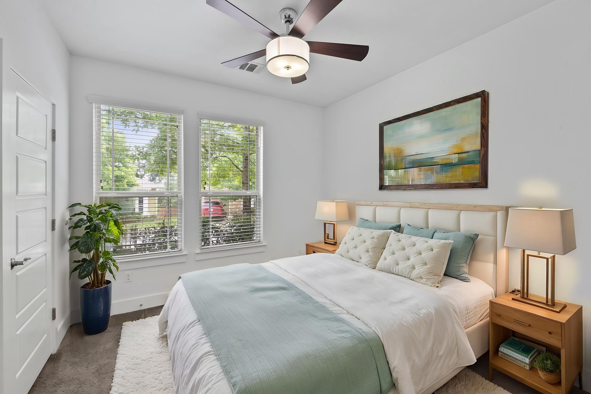 1765 Rowdy Loop, Unit 47 Leander, TX 78641 - Photo 22 of 39 Bright bedroom featuring two large windows, a ceiling fan with integrated lighting, a paneled door, and dark flooring