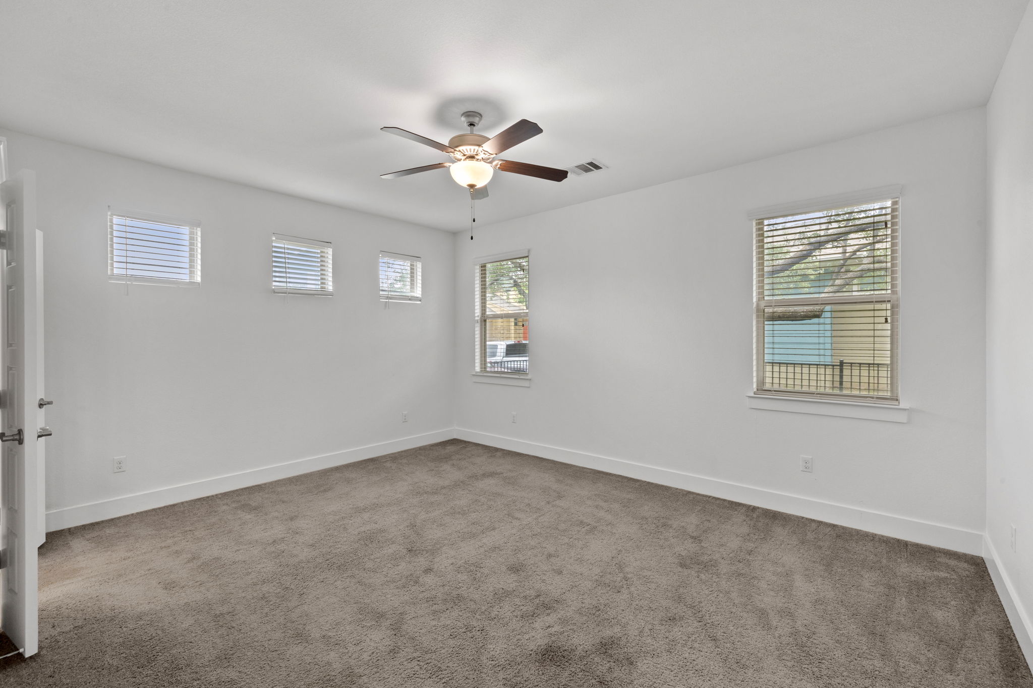 1765 Rowdy Loop, Unit 47 Leander, TX 78641 - Photo 25 of 39 Carpeted room with a ceiling fan, multiple windows, and white walls