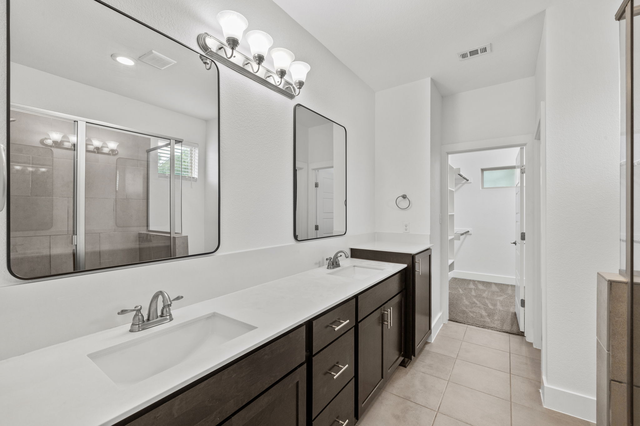 1765 Rowdy Loop, Unit 47 Leander, TX 78641 - Photo 29 of 39 Dual vanity with white countertops, dark wood cabinetry, and rectangular undermount sinks