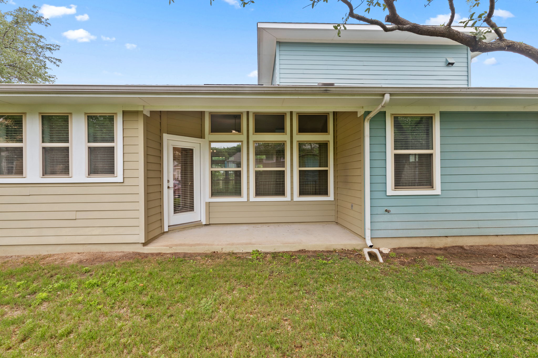 1765 Rowdy Loop, Unit 47 Leander, TX 78641 - Photo 37 of 39 Rear patio with concrete surface, exterior siding in contrasting tones, multiple windows, and a glass-paneled door