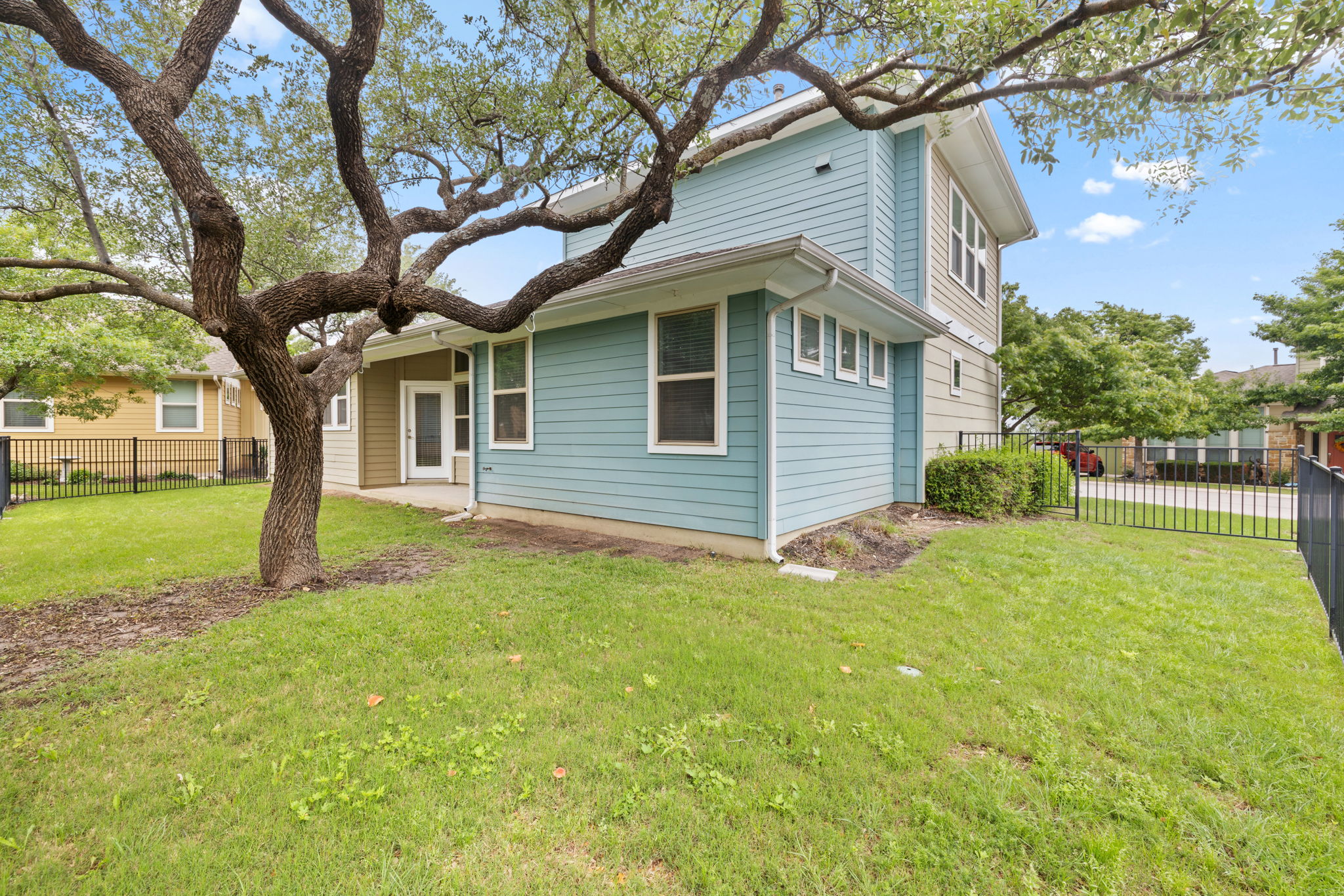1765 Rowdy Loop, Unit 47 Leander, TX 78641 - Photo 38 of 39 Exterior featuring light blue and beige horizontal siding, multiple windows, and a paved patio area