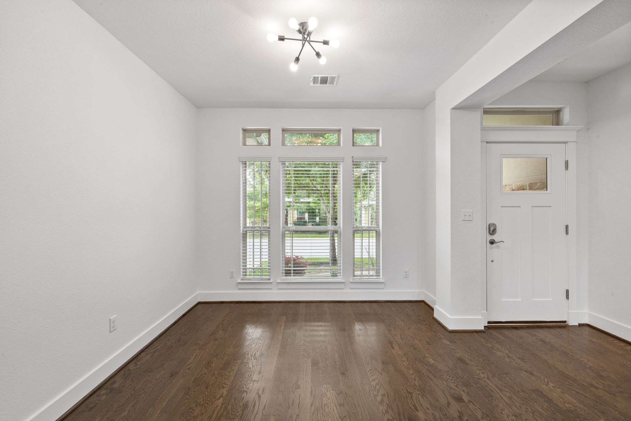 1765 Rowdy Loop, Unit 47 Leander, TX 78641 - Photo 7 of 39 Entry area featuring a contemporary front door with an upper window panel, dark wood-finish flooring, and white baseboards