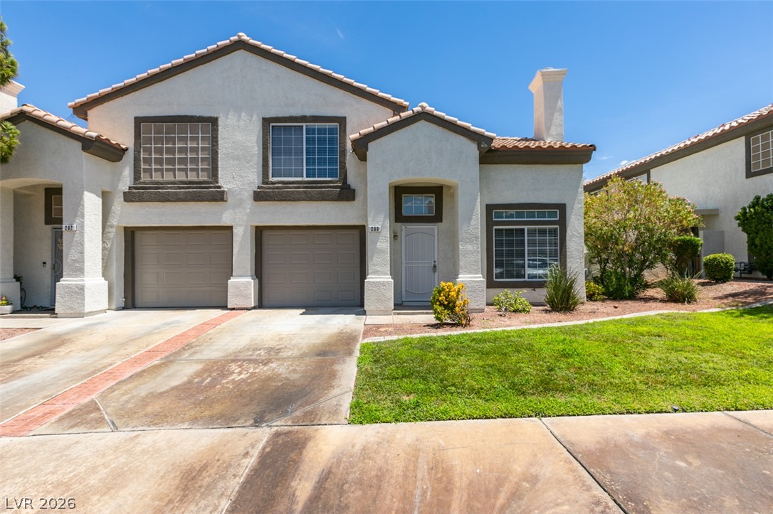 200 Luninborg Street Henderson, NV 89074 - Photo 1 of 40 A well-maintained facade features an attached two-car garage and manicured front lawn.