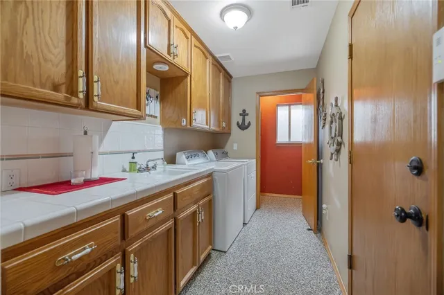 a view of a patio with table and chairs potted plants and large tree