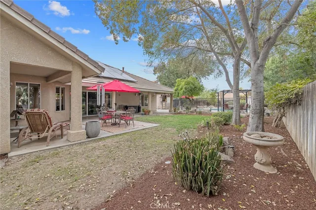 a view of a backyard with plants and a table and chair