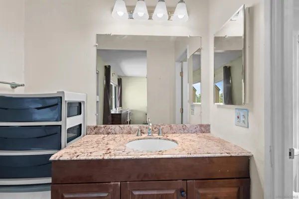 a bathroom with a granite countertop sink and a mirror