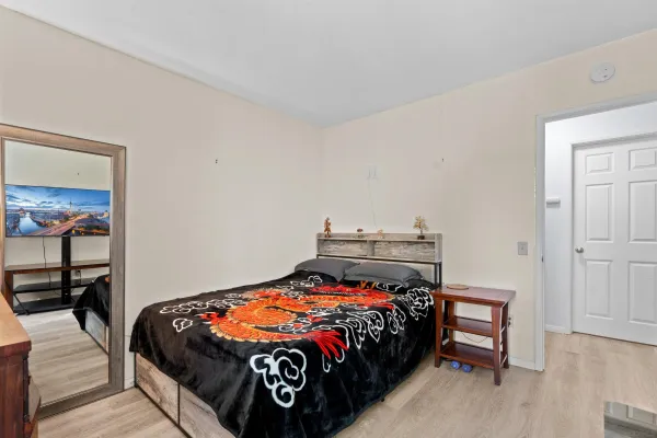 a bedroom with a bed and wooden floor