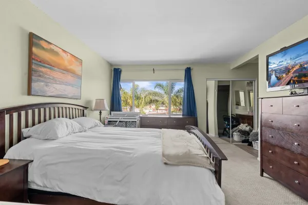 a large bed sitting in a bedroom next to a window
