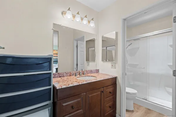 a bathroom with a granite countertop sink toilet a large mirror a shower and