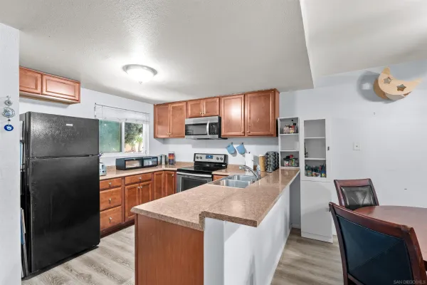 a kitchen with stainless steel appliances granite countertop a refrigerator stove microwave and sink
