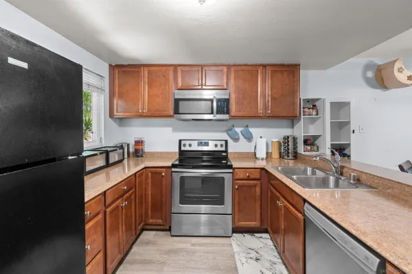 a kitchen with stainless steel appliances granite countertop a sink stove and refrigerator