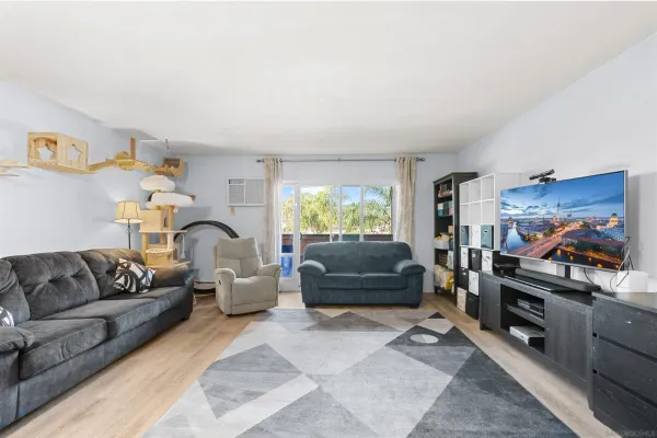 a living room with furniture kitchen view and a window