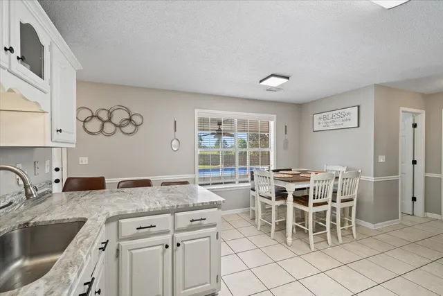 a kitchen with granite countertop cabinets and chairs
