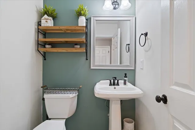 a bathroom with a toilet sink and mirror