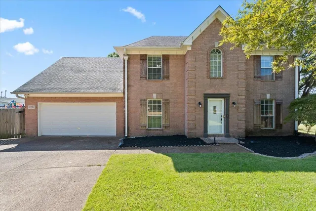 a front view of a house with a yard and garage