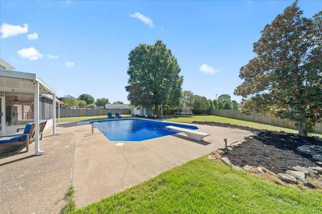 a view of a backyard with swimming pool