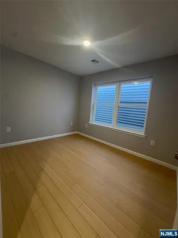 an empty room with wooden floor and closet