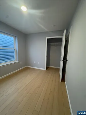 an empty room with wooden floor and a window
