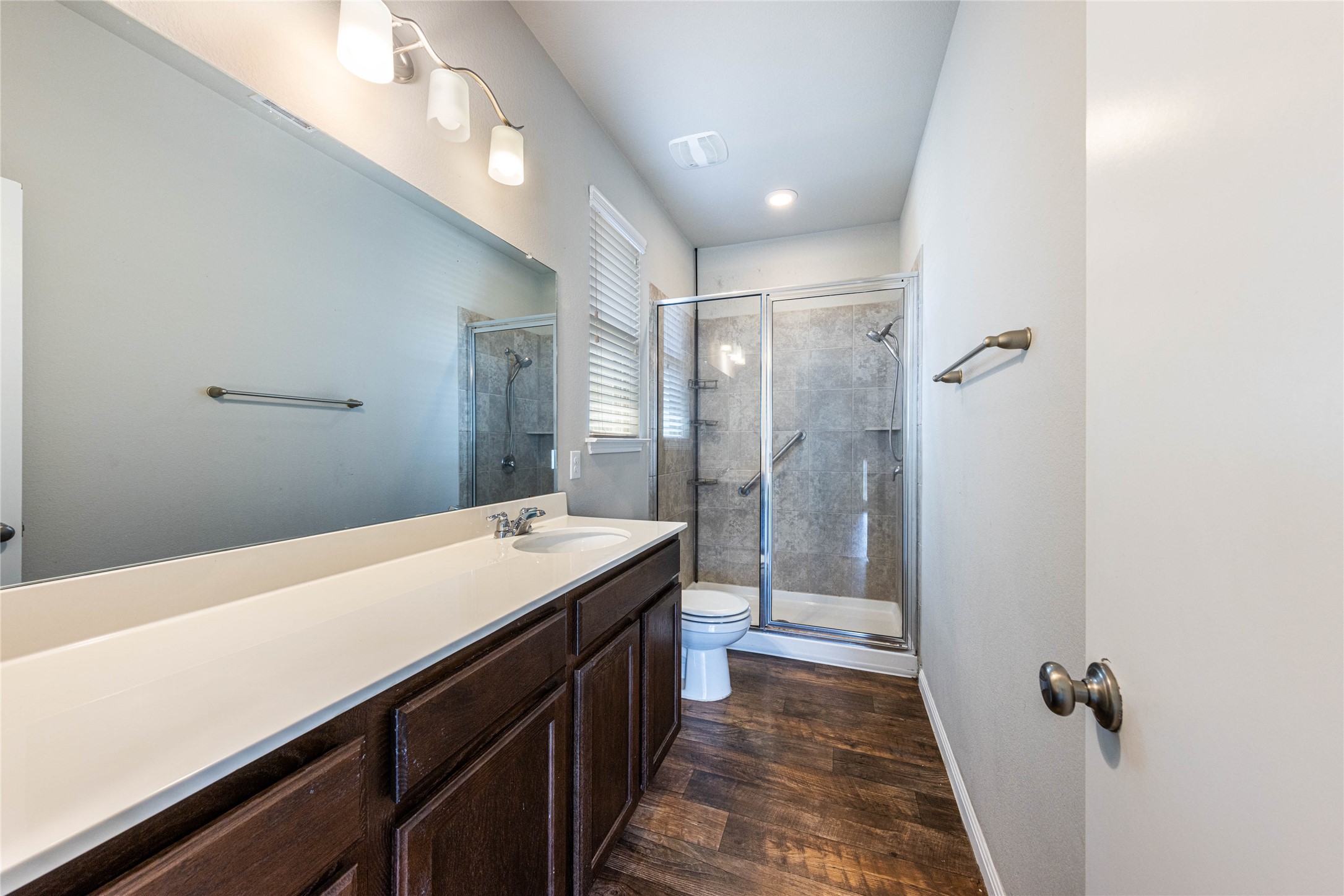 368 Wapiti Road Buda, TX 78610 - Photo 12 of 20 Spacious bathroom with a dual sink vanity featuring a white countertop and dark wood-finish cabinetry